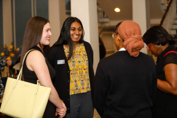 A candid photo of four women conversing at the George Eastman Circle Faculty & Staff Reception held on March 30, 2023 within Rochester New York.