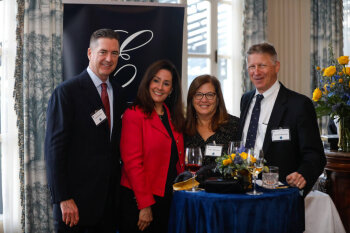 COVER Photo. Four individuals pose and smile for a photo at the George Eastman Circle Faculty & Staff Reception held on March 30, 2023 within Rochester New York.