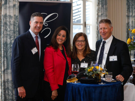 COVER Photo. Four individuals pose and smile for a photo at the George Eastman Circle Faculty & Staff Reception held on March 30, 2023 within Rochester New York.