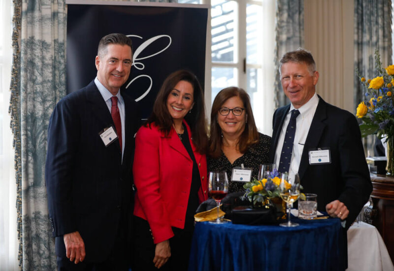 COVER Photo. Four individuals pose and smile for a photo at the George Eastman Circle Faculty & Staff Reception held on March 30, 2023 within Rochester New York.