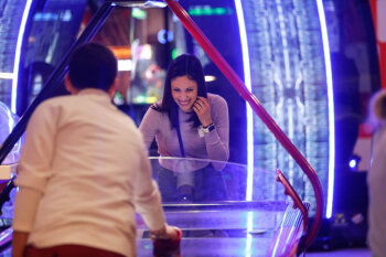 A candid photo of a man and woman playing air hockey at the George Eastman Circle Family Celebration, held on April 27, 2023 within Rochester New York.