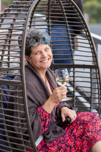Woman sitting in a wicker hanging seat