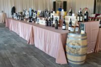 auction table with many bottles of wine, wooden boxes, and cards with their lot numbers