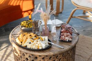 cheese, meat, and olive trays on a wicker table