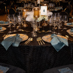 Round table set up with dishes, untensils, napkins nicely laid out