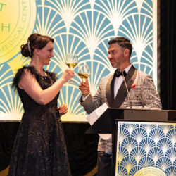 2 people at a lecturn clinking their champaign