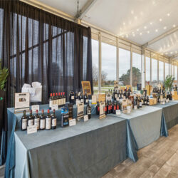 A line of tables with wine bottles on them