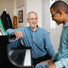 Howard Spindler teaching student the piano