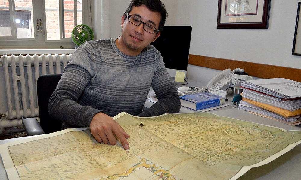 Pablo Sierra in his office, points to map