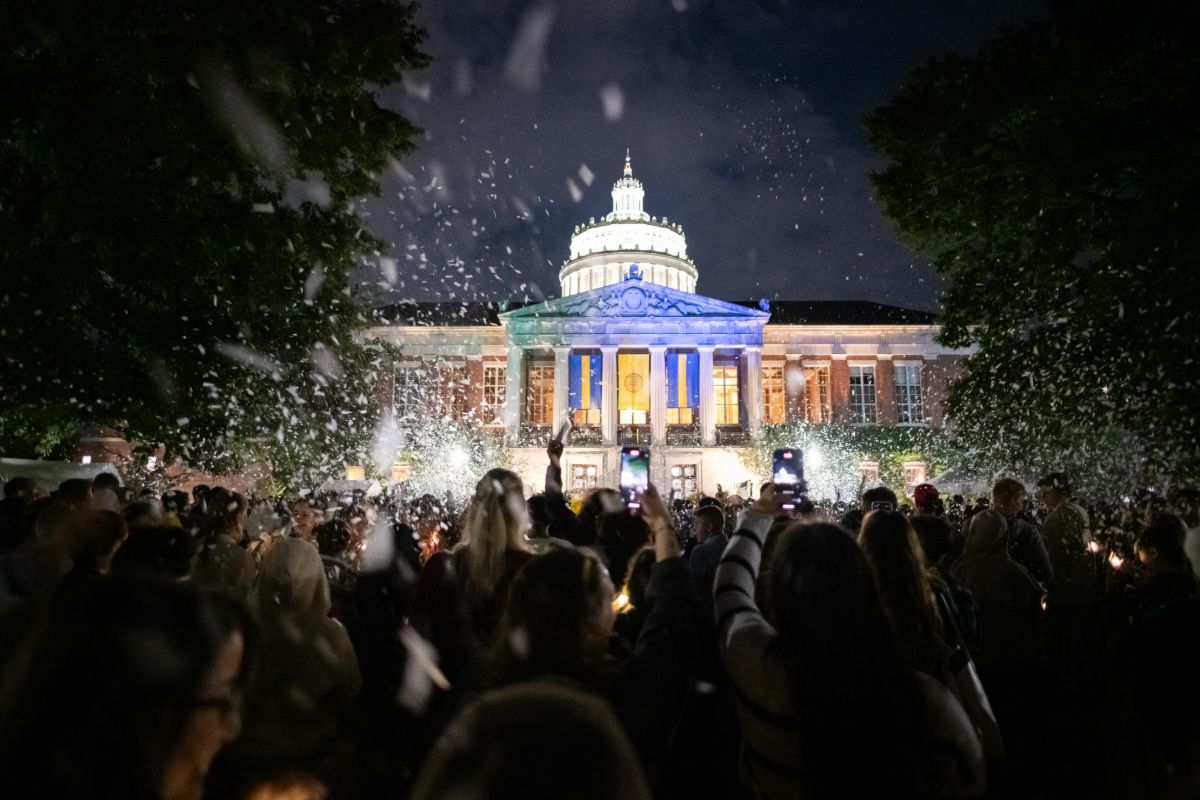 Attendees participate in the University of Rochester Candlelight ceremony in front of the University's library.