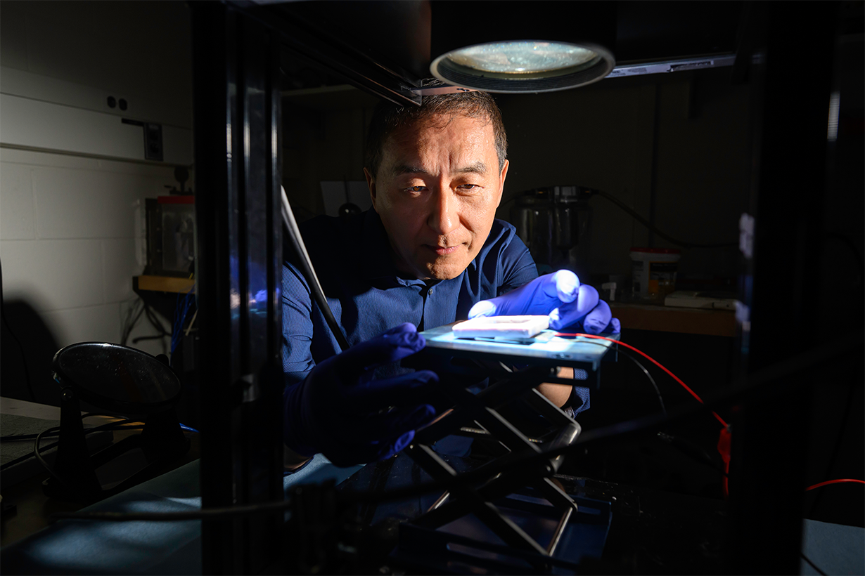 University of Rochester Institute of Optics professor Chunlei Guo uses a source of simulated sunlight to test the absorption of a solar thermoelectric generator created in his lab.