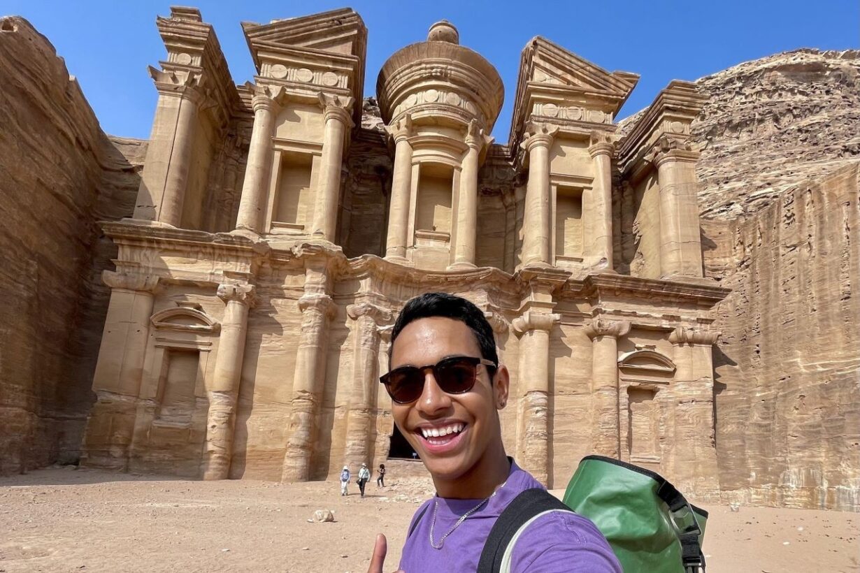 A URochester student take a selfie in from of a building while abroad.