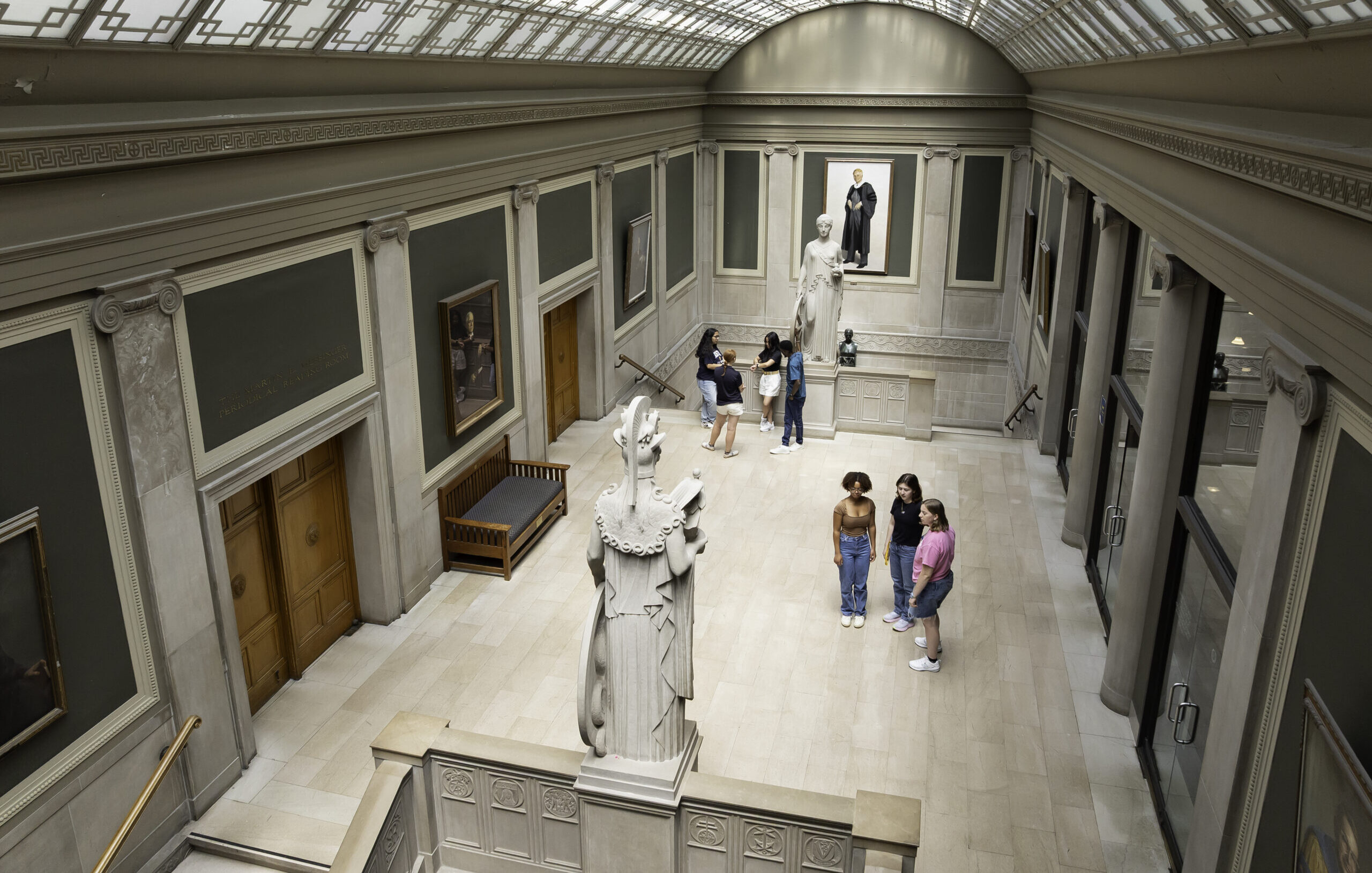 Students tour a gallery-like, interior space in Rush Rhees Library.