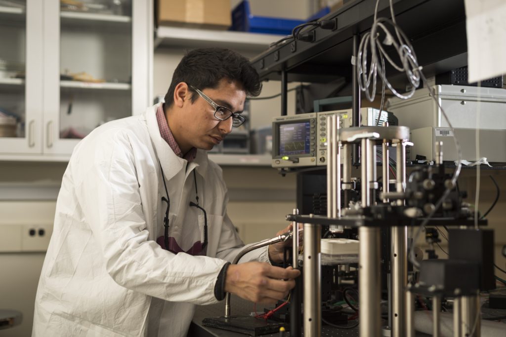 A University of Rochester student in a laboratory tinkering with metal equipment