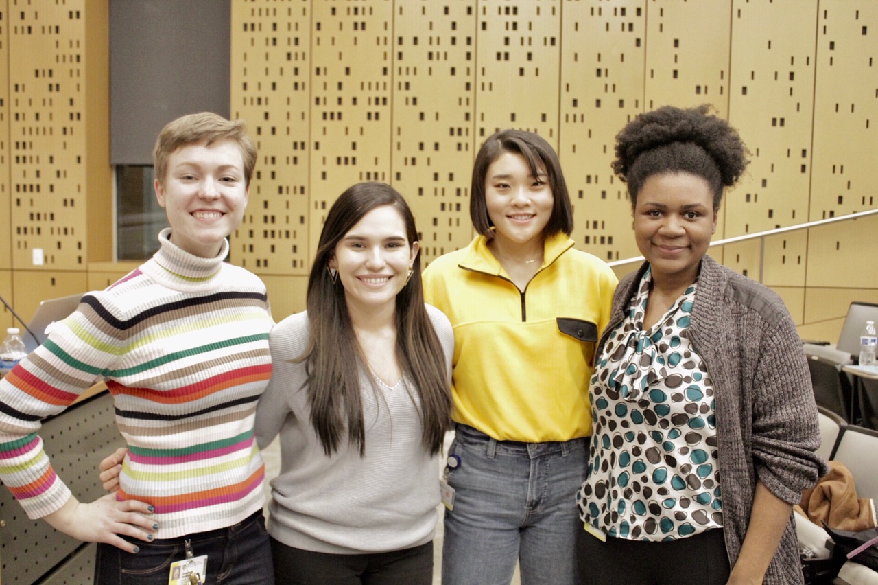 A group of ADSE students smiling together in a lecture hall after a Meet & Greet event