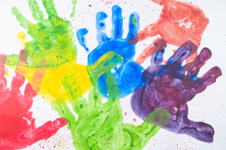 Kids hand paint on white paper with multiple colors