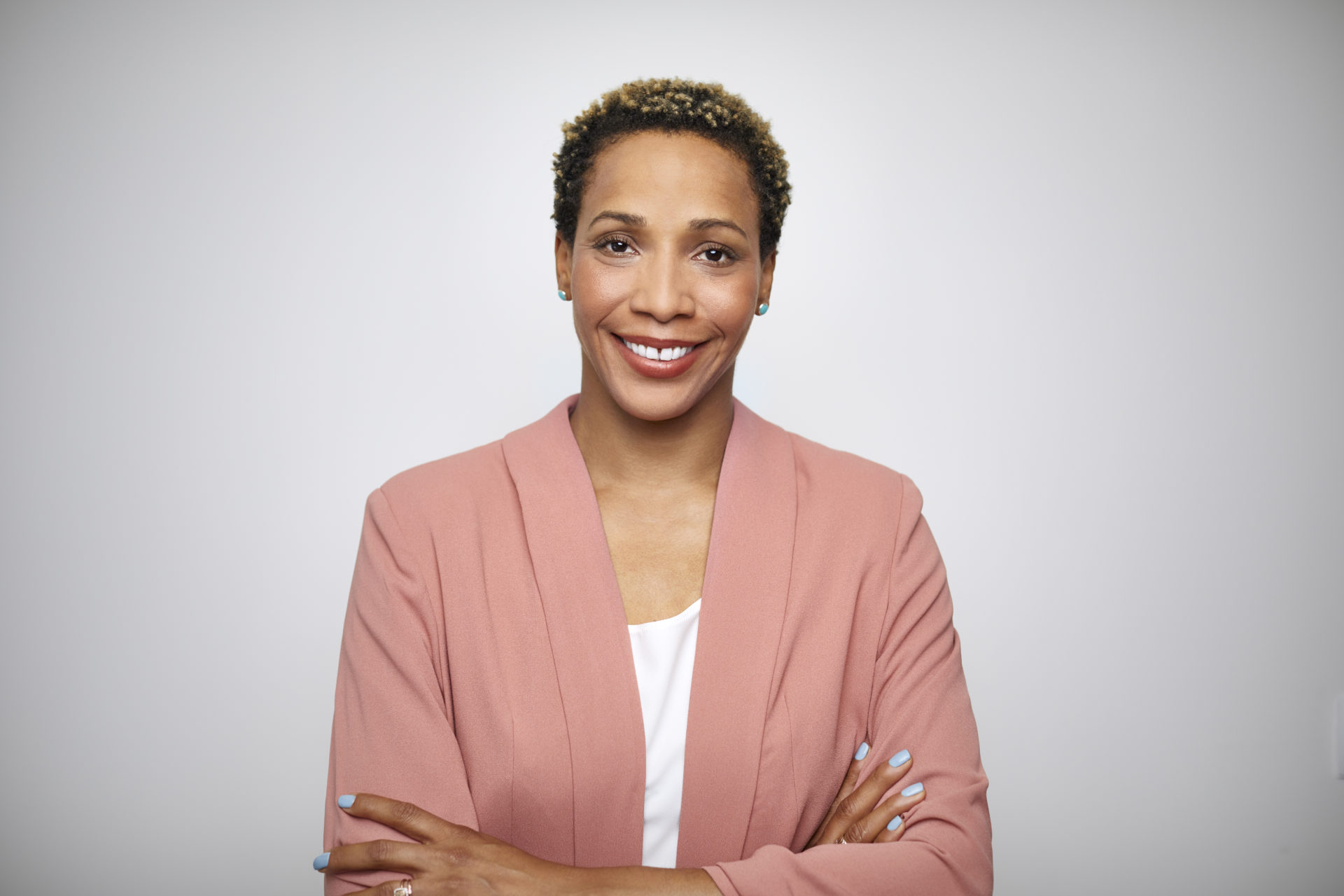 Woman smiling with arms crossed in business attire