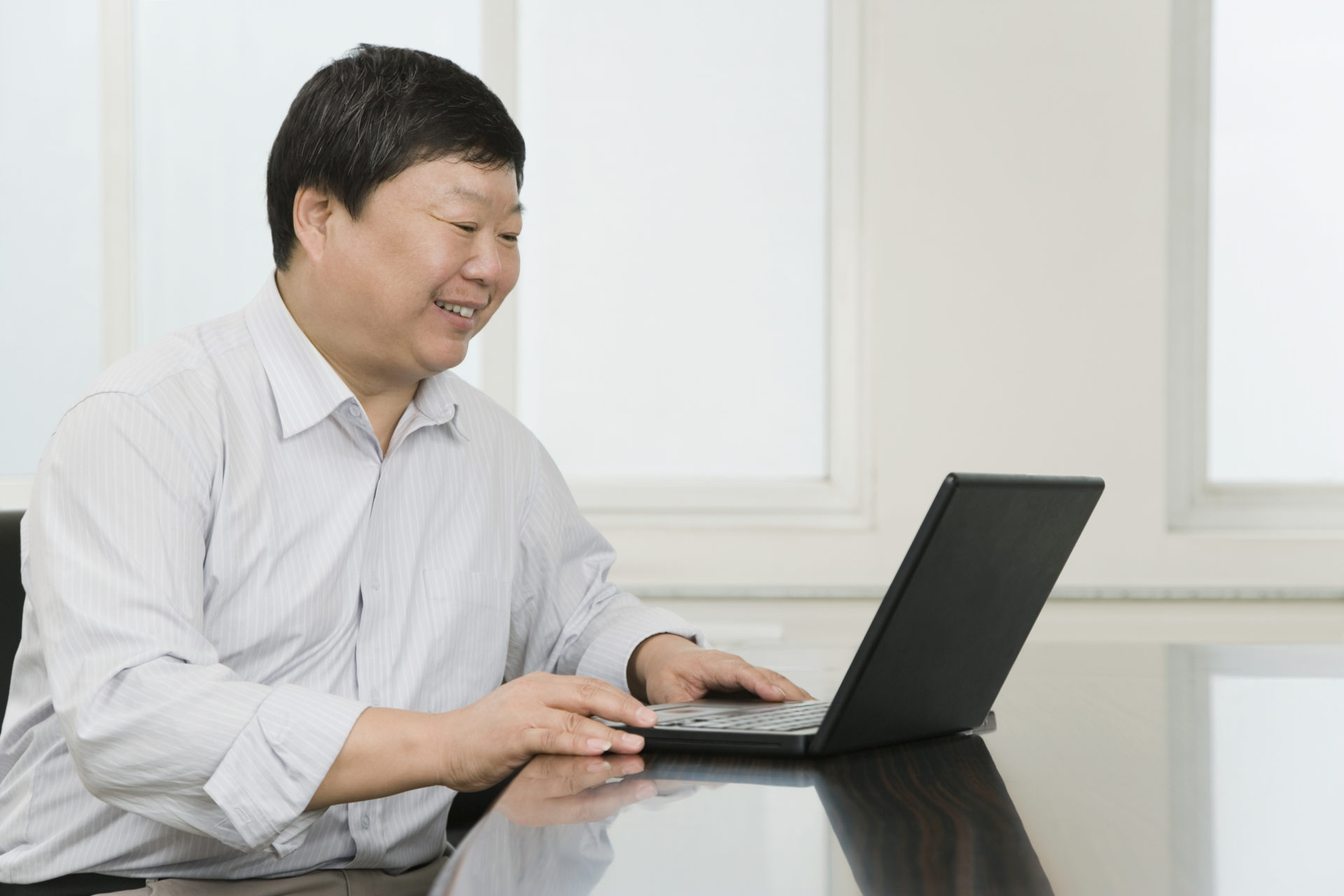 Businessman using laptop, smiling