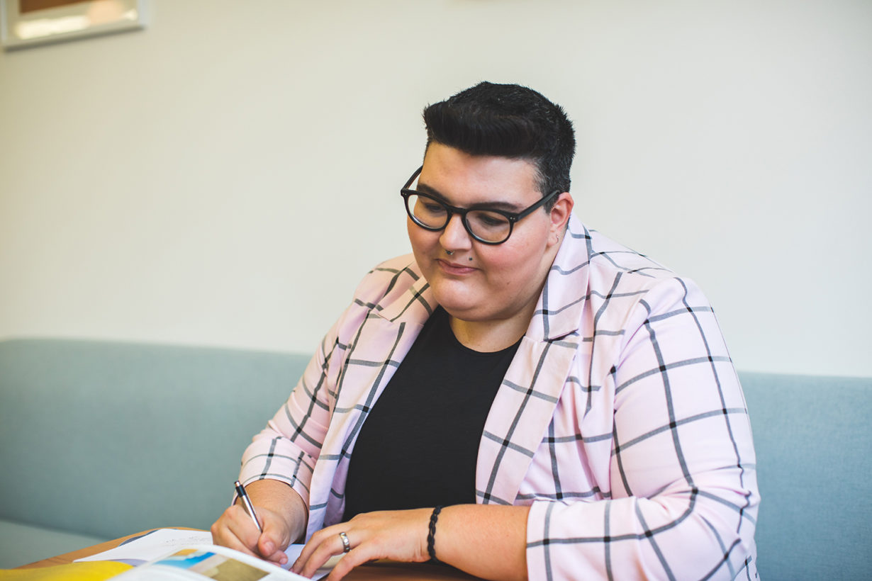 person seated at a table works on paperwork