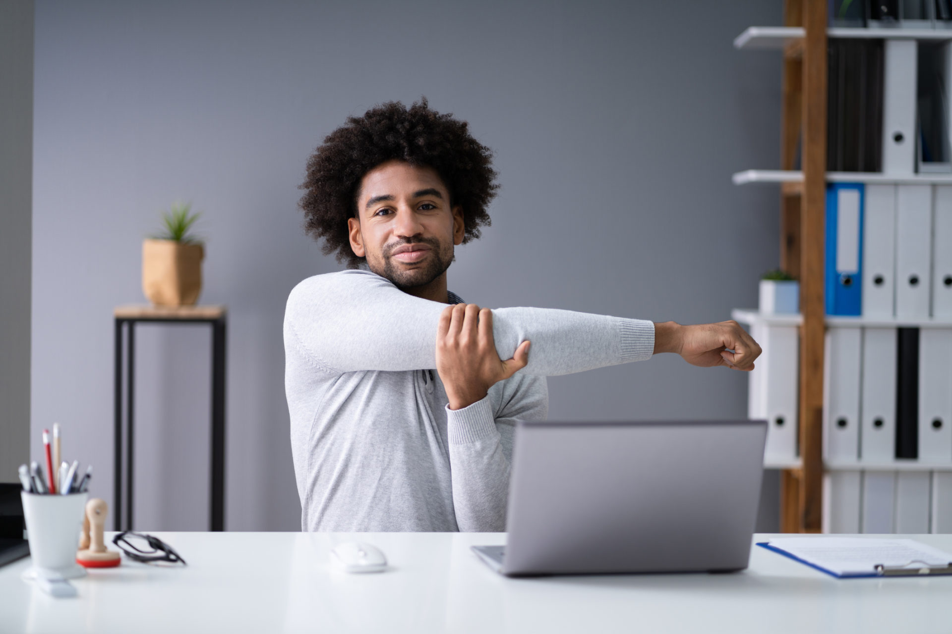 Businessman Stretching His Arms In His Office