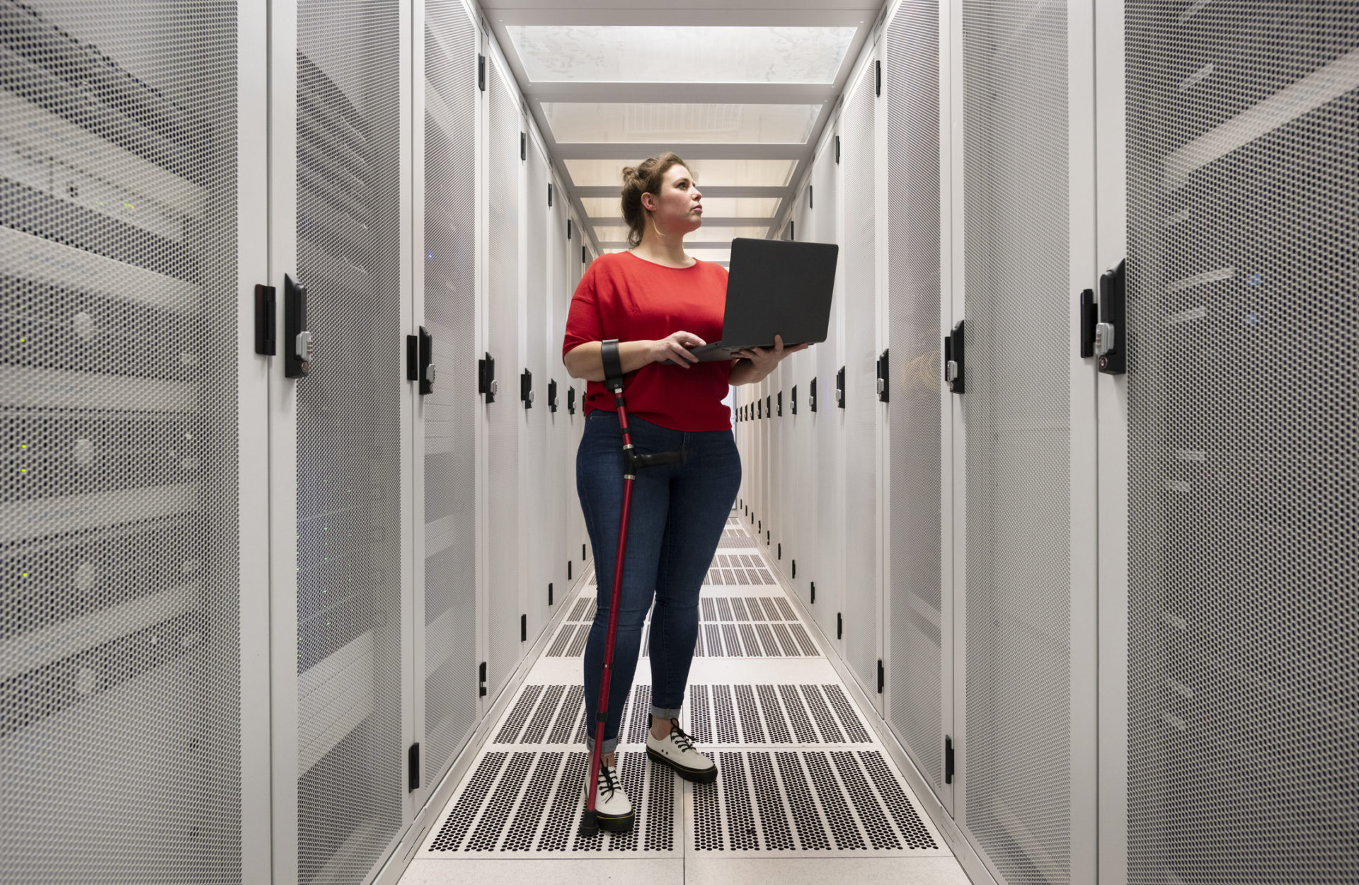 Woman holding a laptop working in a data center