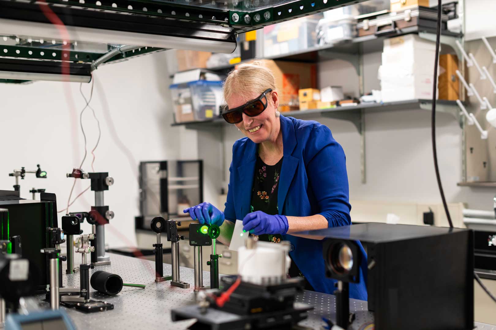 Astrid Müller, assistant professor in chemical engineering, aligns a laser in her lab.