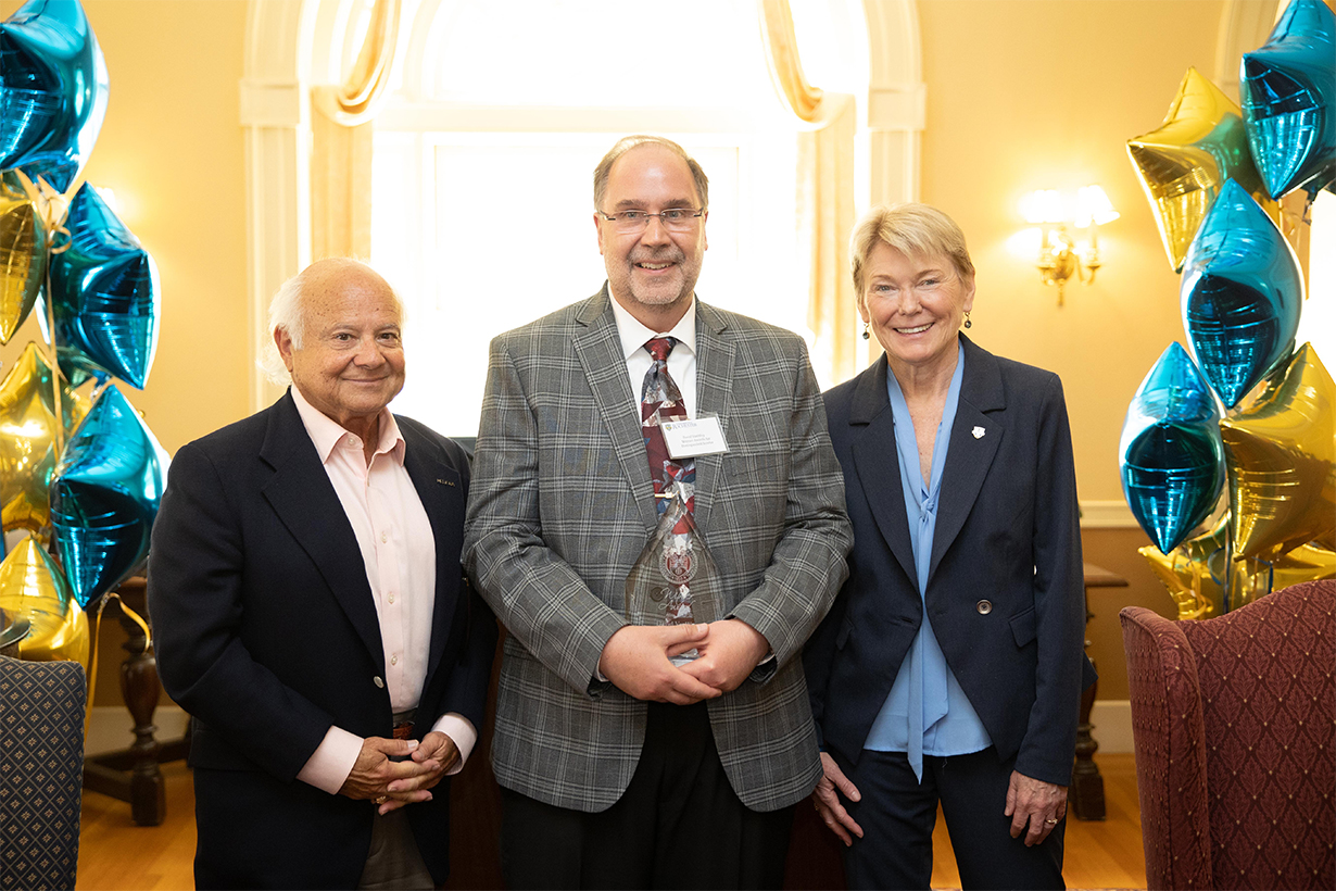 David VanWey, HR/Benefits Representative and Lead Analyst; Programmer, Laboratory for Laser Energetics, receives the Witmer Award for Distinguished Service. Left: Larry Kessler, trustee; right: President Sarah Mangelsdorf.