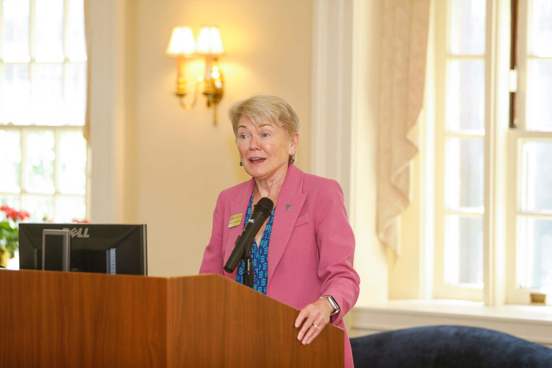 President Sarah Mangelsdorf standing behind a podium giving a speech.