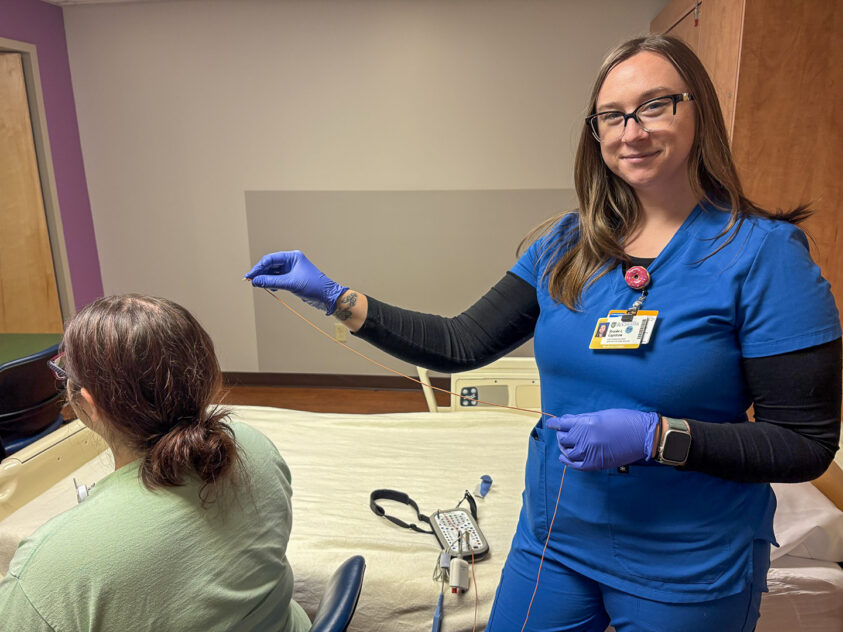 Brooke Capstraw, (right) RPSGT, shows how she prepares monitoring equipment before beginning a sleep study with a model patient (left).