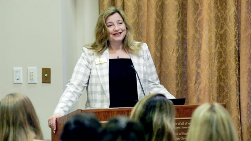 Kathy Gallucci talking from a podium in front of a group.