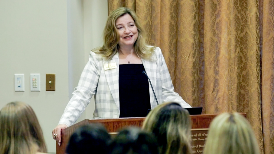 Kathy Gallucci talking from a podium in front of a group.