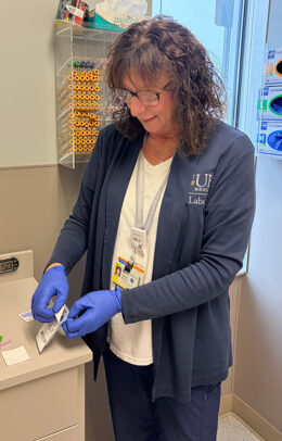 A woman named, Debra McGurn, in a lab office prepping for a blood draw.