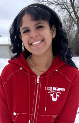 A woman named, Kalissa Marks, smiling brightly in the winter wearing a red jacket.