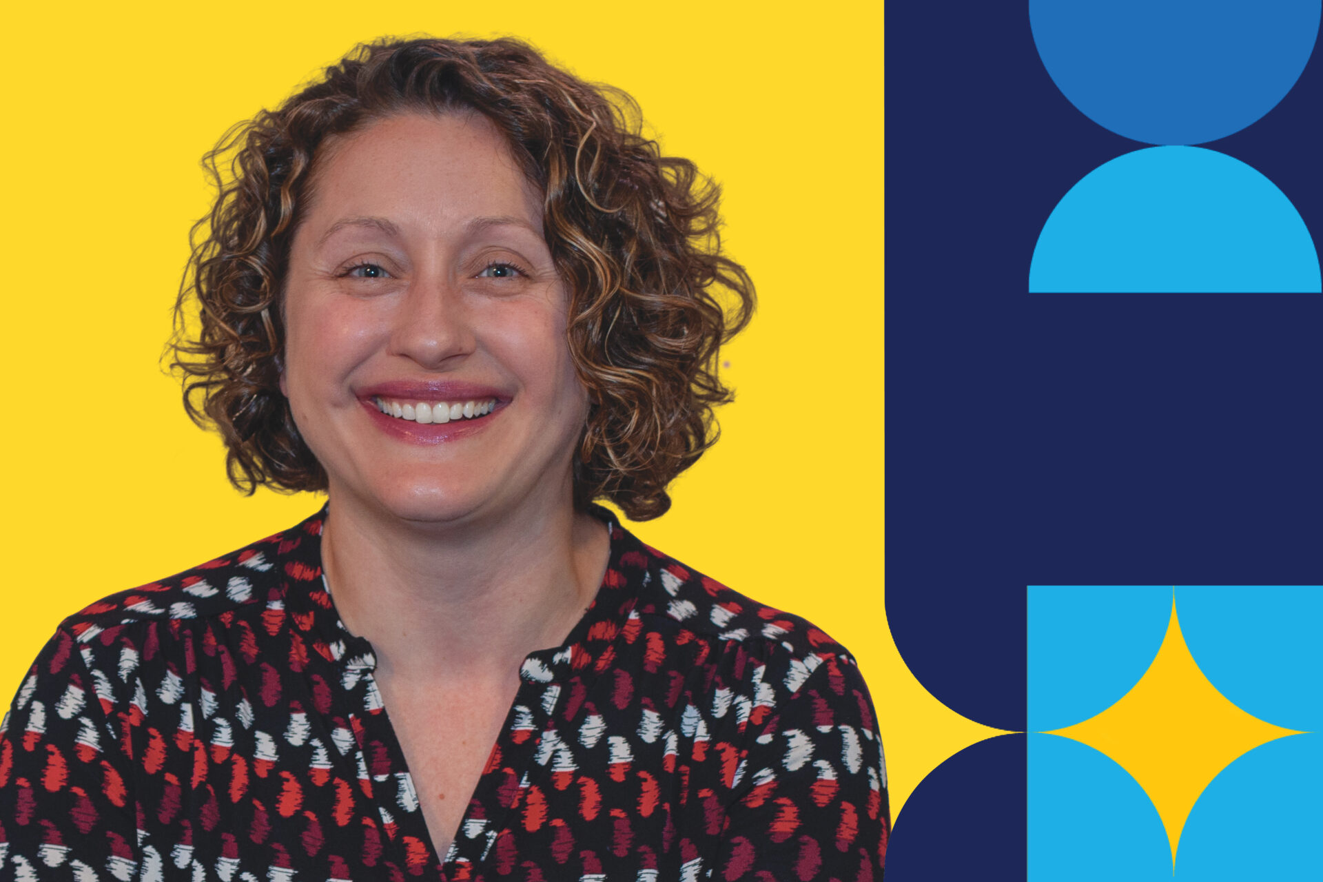 A woman named, Liz Yockel, smiling brightly in front of a yellow background.