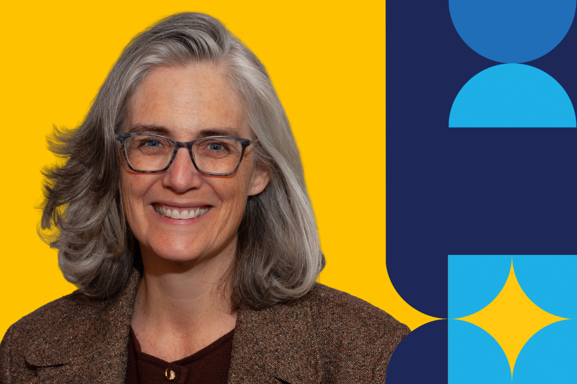 A woman named Kim Fluet is smiling brightly in a brown jacket in front of a yellow background.