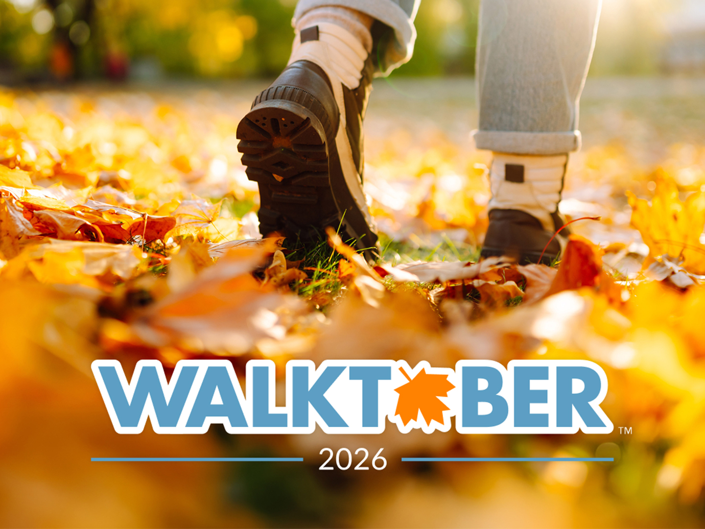 A person walking in the fall season with fallen leaves scattered on the ground with the text 'Walktober: 2026' at the bottom.