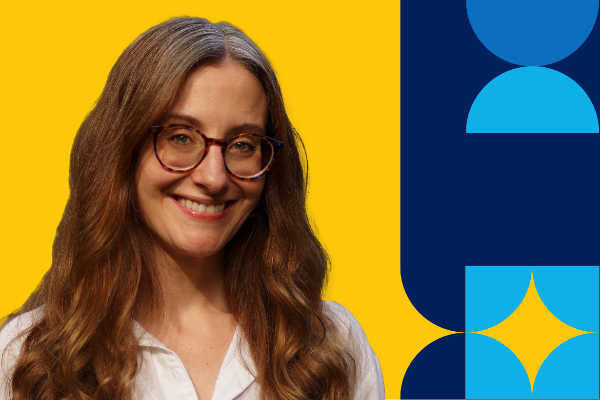 A woman named Raina Tinker is smiling brightly, wearing a pair of glasses, in a white blouse, in front of a yellow background from shoulders up.