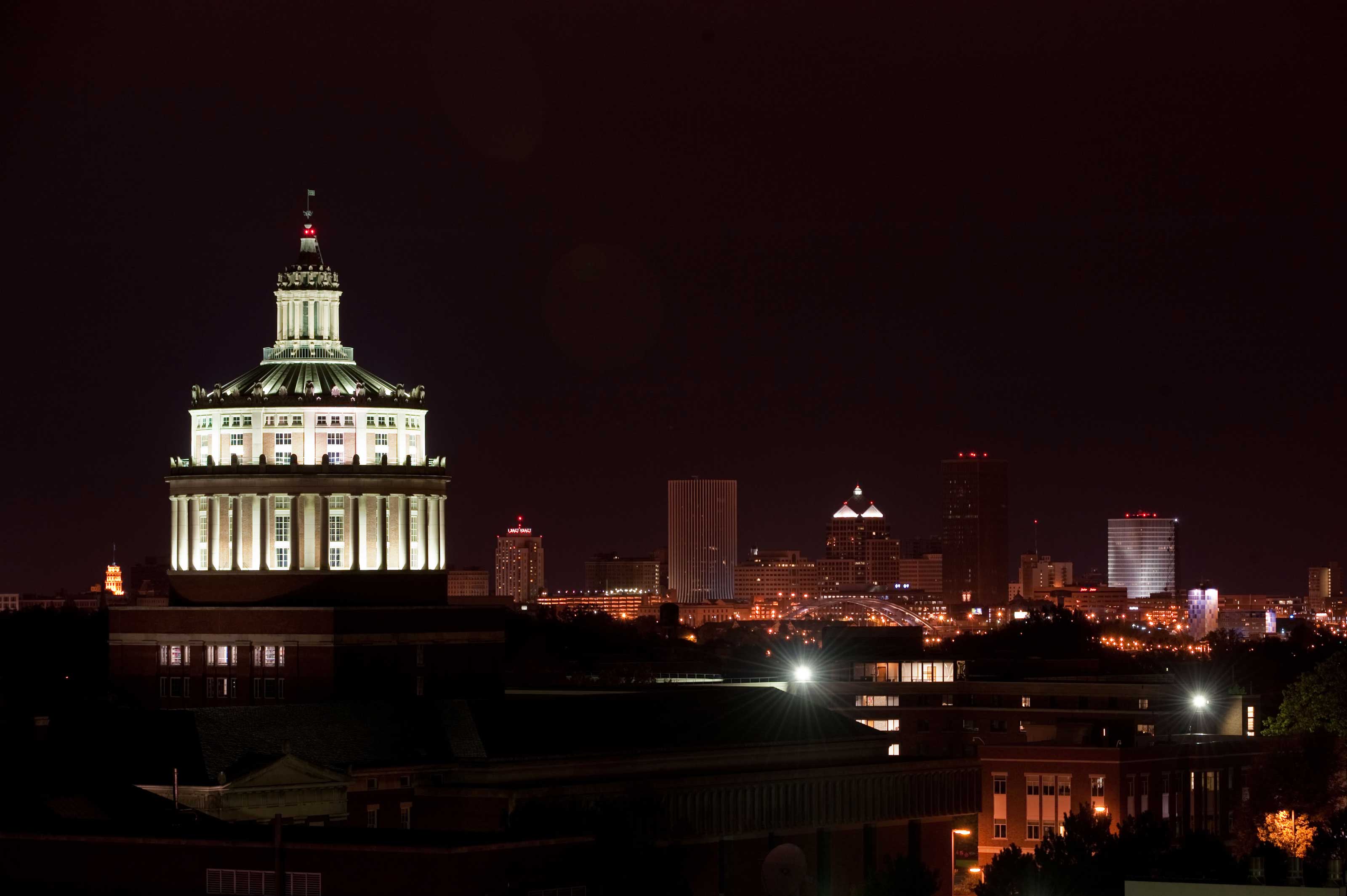 Rush Rhees library tower and city skyline at night