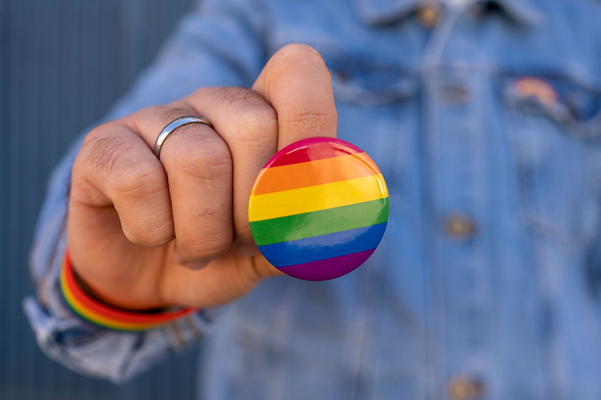 A person is holding a vibrant rainbow-colored button, showcasing a spectrum of colors in their hand.