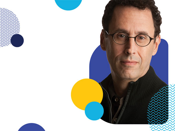 headshot of Tony Kushner with blue background and yellow and blue circles