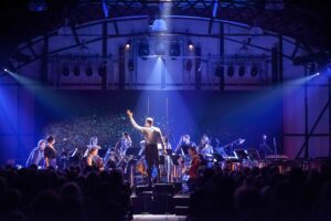 A conductor conducting an orchestra in blue light