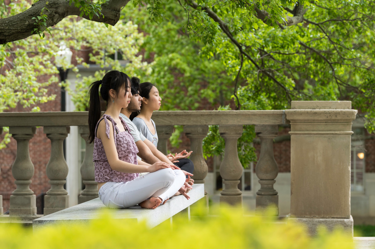 Students meditating on the University of Rochester river campus