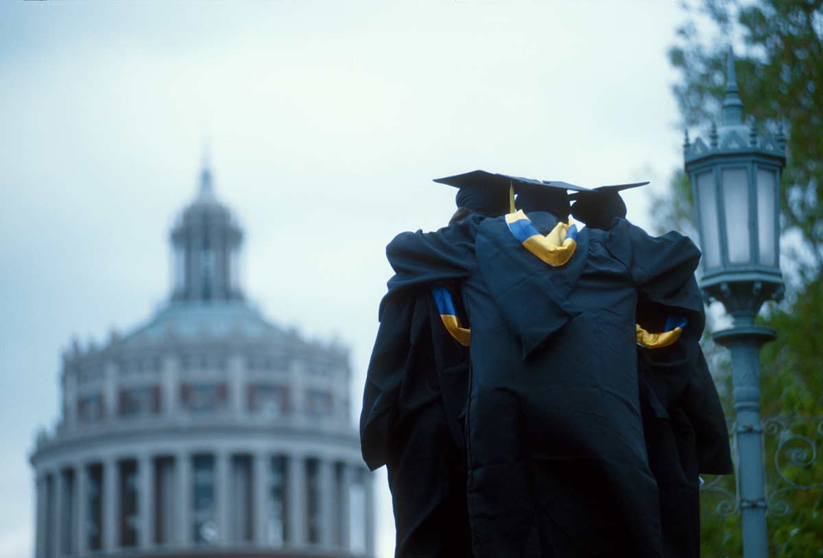 three graduates hugging