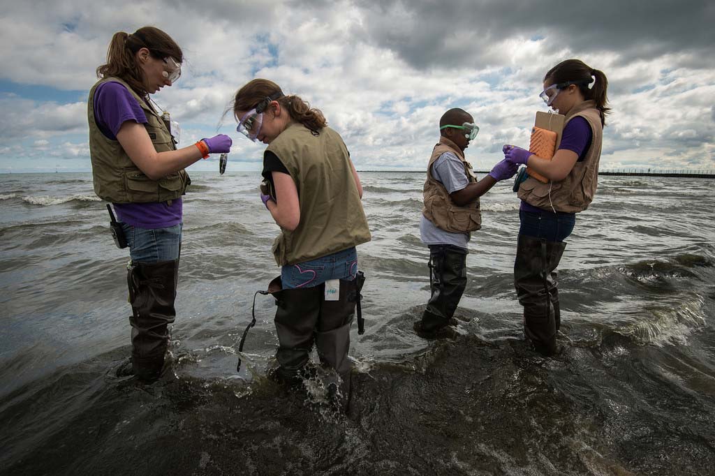 students standing on the shore of a lake