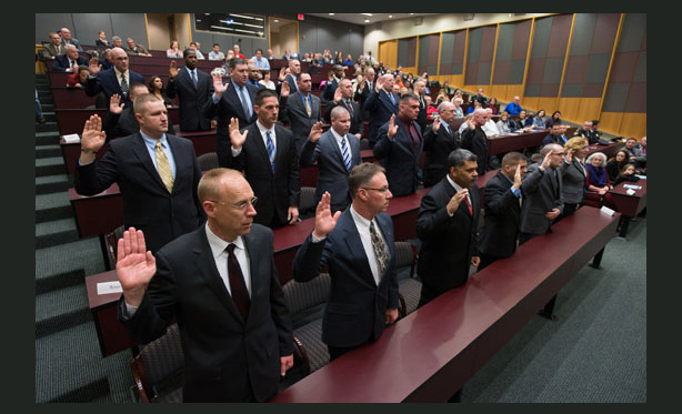Feature image men raising hands in auditorium