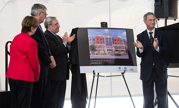 Feature image people applauding on stage next to rendering of Paprocki Plaza