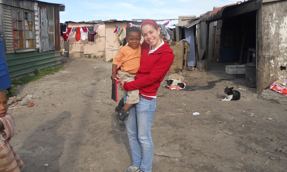 Feature image student holding a child at a community center in Egoli, South Aftica