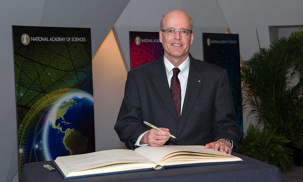 Richard Aslin signing a ledger