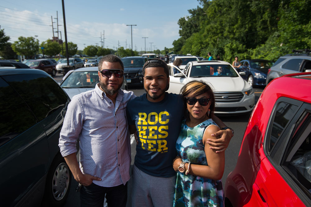 student poses for a photo with his parents