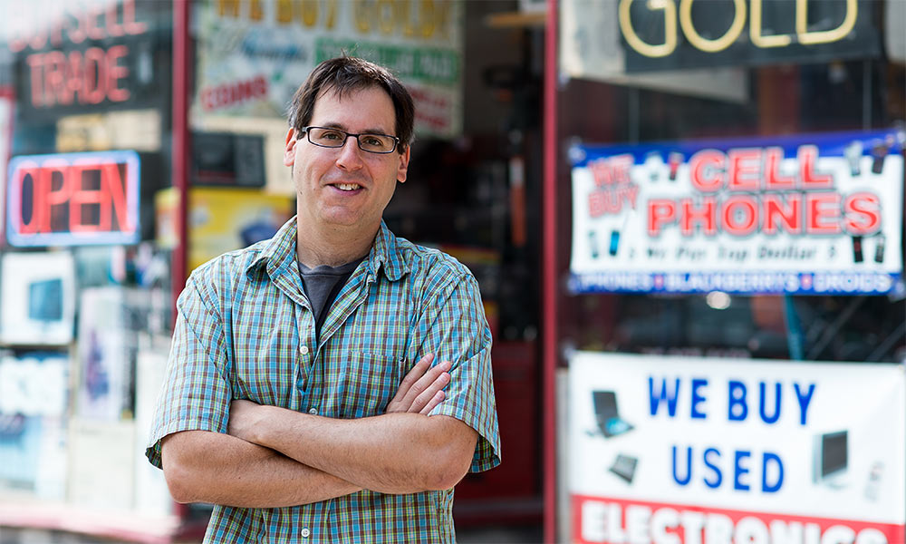 man in front of pawn signs.